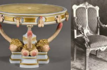 An ornate circular table with a marble top, supported by three elephant heads with tusks and trunks forming the base, paired with an intricately carved chair with a high backrest and cushioned seat.