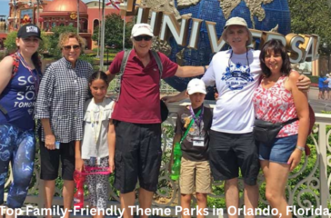 A group of visitors posing for a photo at the entrance of Universal Studios in Orlando, Florida, with the iconic rotating globe and park name in the background.