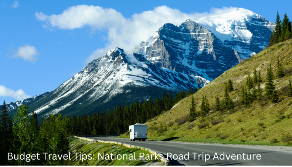 A scenic view of a highway leading through a mountainous landscape with lush greenery and a clear blue sky. A recreational vehicle is seen traveling on the road, with towering snow-capped mountains in the background.